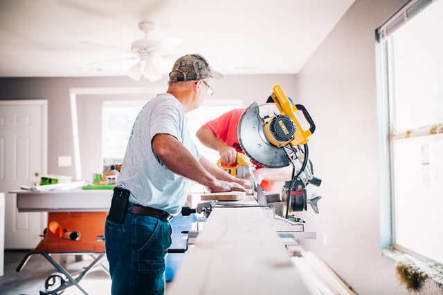 carpenters cutting wood on saw